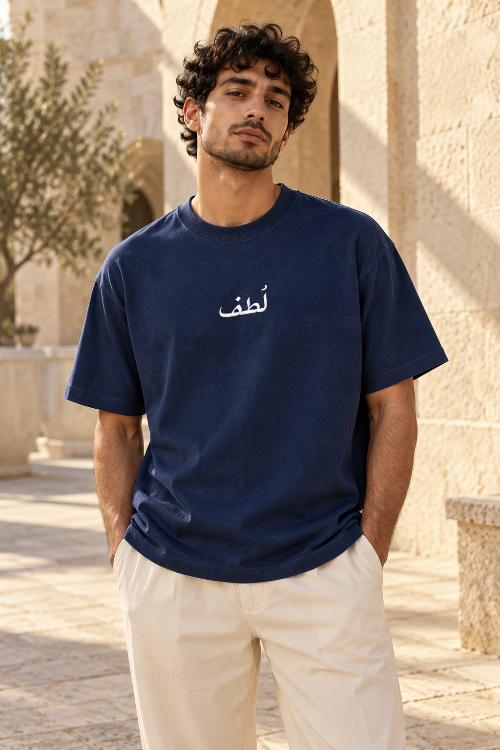 the LUTF navy tee worn in a sunlit limestone courtyard